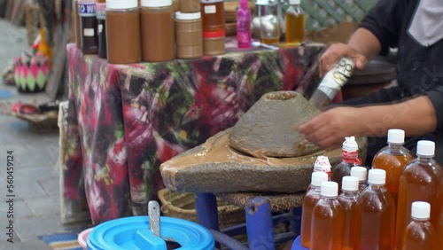 Berber Woman Grinds Argan Almonds in Stone Hand Mill Making Argan Oil in Morocco