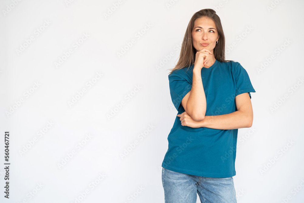 Portrait of thoughtful young woman looking at copyspace. Female Caucasian model with brown hair and grey eyes in casual clothes touching chin with hand thinking. Advertising concept Portrait of thoughtful young woman looking at copyspace. Female Caucasian model with brown hair and grey eyes in casual clothes touching chin with hand thinking. Advertising concept