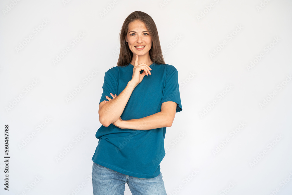 Portrait of cheerful young woman holding her chin with finger. Female Caucasian model with brown hair and grey eyes in turquoise T-shirt and casual jeans smiling propping her head. Lifestyle concept Portrait of cheerful young woman holding her chin with finger. Female Caucasian model with brown hair and grey eyes in turquoise T-shirt and casual jeans smiling propping her head. Lifestyle concept