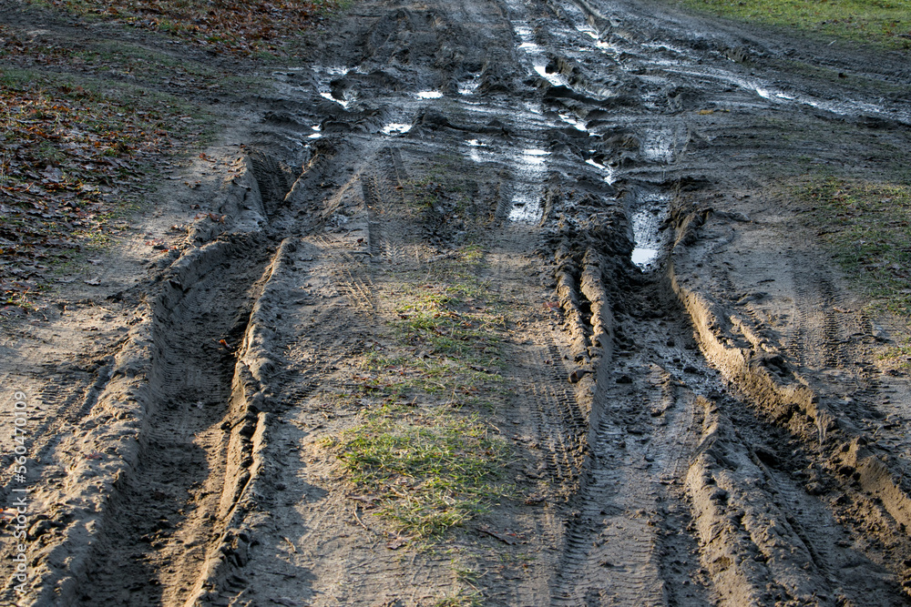 Dirt road after heavy rain. Traces of car tires on a dirt road after rain. Traces of automobile wheels in liquid mud. driving hazard