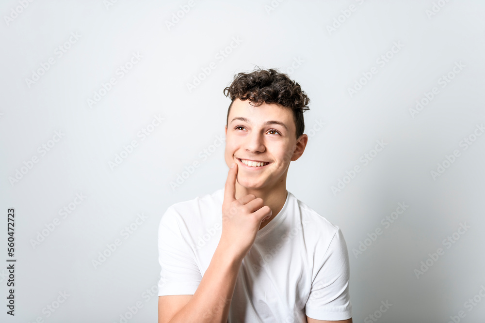 White t-shirt on teen boy. Handsome pensive caucasian isolated on a white background