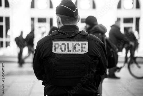 Portrait on back view of french police man standing in the street