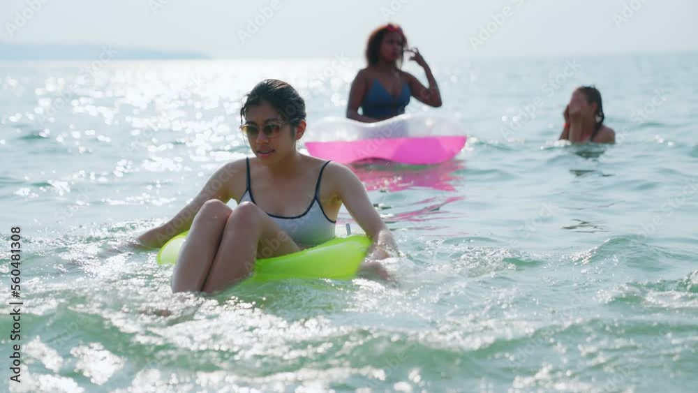 Groups of multi-ethnic teenage girls play in the sea, friends having fun, relaxing, playing on rubber ring in the evening. Lifestyle, friends, travel, vacation, beach. Sea On Summer Vacation. Groups of multi-ethnic teenage girls play in the sea, friends having fun, relaxing, playing on rubber ring in the evening. Lifestyle, friends, travel, vacation, beach. Sea On Summer Vacation.