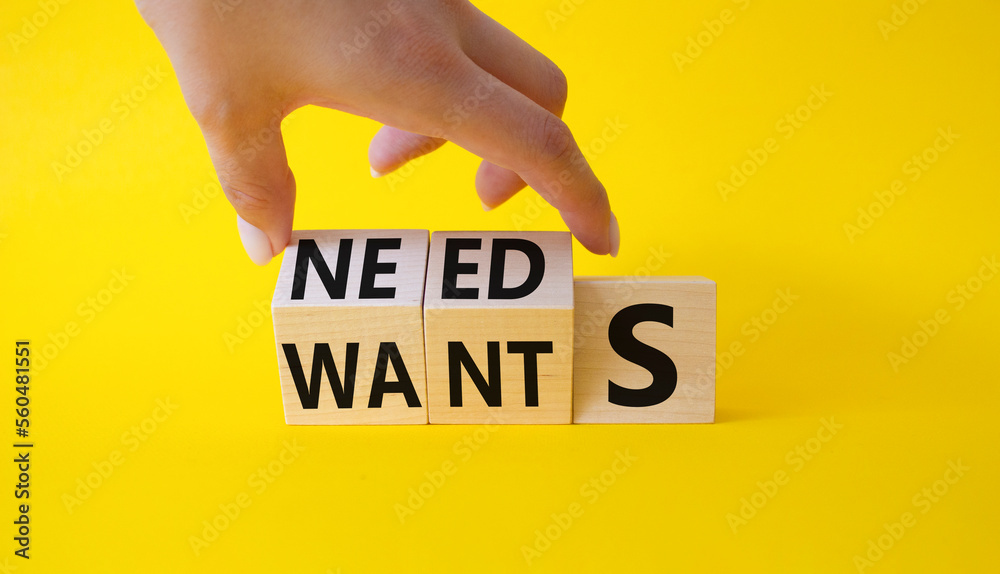Needs and Wants symbol. Businessman Hand turns cubes and changes word ...