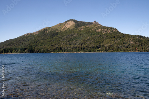View of Gutierrez lake in Bariloche, Patagonia Argentina. The turquoise water, rocky shallows and mountains in the horizon.