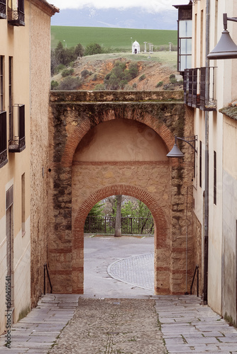 Puerta de Sol street with architectural arch. Segovia  Espa  a.
