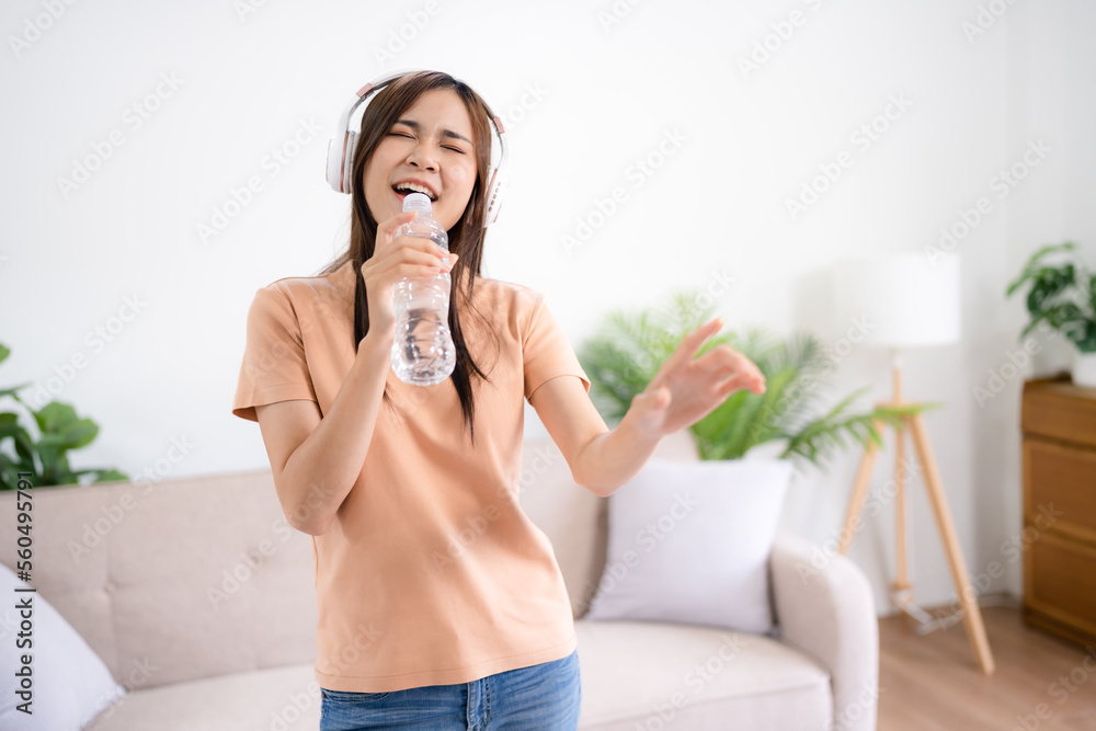 Young asian woman singing song and dancing..happy funny girl wearing headset enjoying at home Young asian woman singing song and dancing..happy funny girl wearing headset enjoying at home