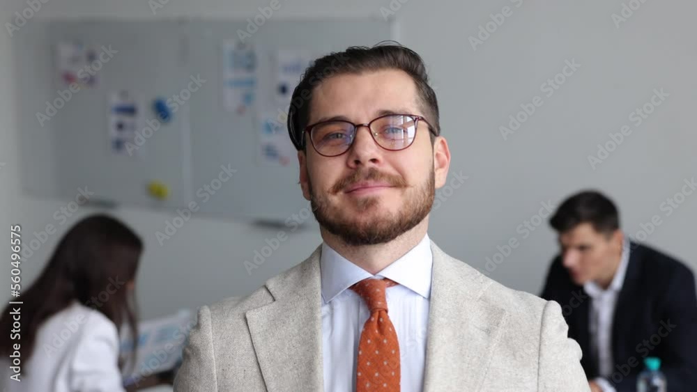 successful entrepreneur creator of a startup in glasses and a business suit on the background of a working colleague successful entrepreneur creator of a startup in glasses and a business suit on the background of a working colleague