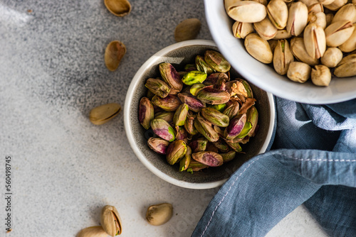 Overhead view of a bowl of pistachio nuts in shells next to a bowl of shelled pistachios photo