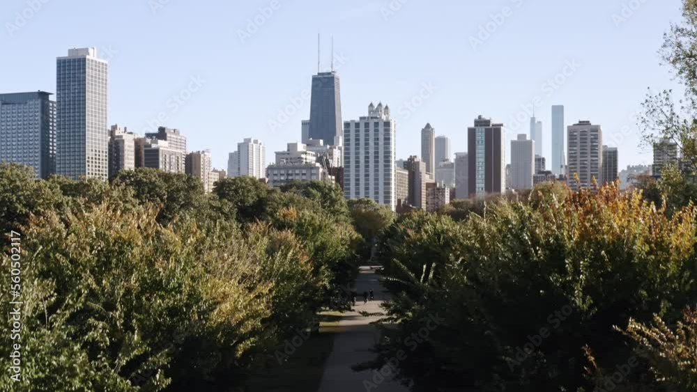 Rising up aerial view between a tree lined pedestrian walkway towards downtown Chicago skyline on a sunny autumn day. Rising up aerial view between a tree lined pedestrian walkway towards downtown Chicago skyline on a sunny autumn day.