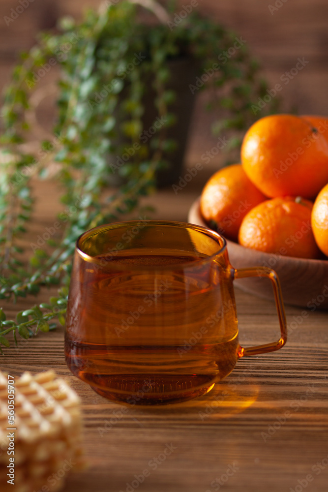 A cup of vitamin tea with tangerines is on the table A cup of vitamin tea with tangerines is on the table
