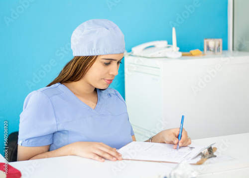 Konstfotografi health personnel secretary writing with her left hand sitting on a desk