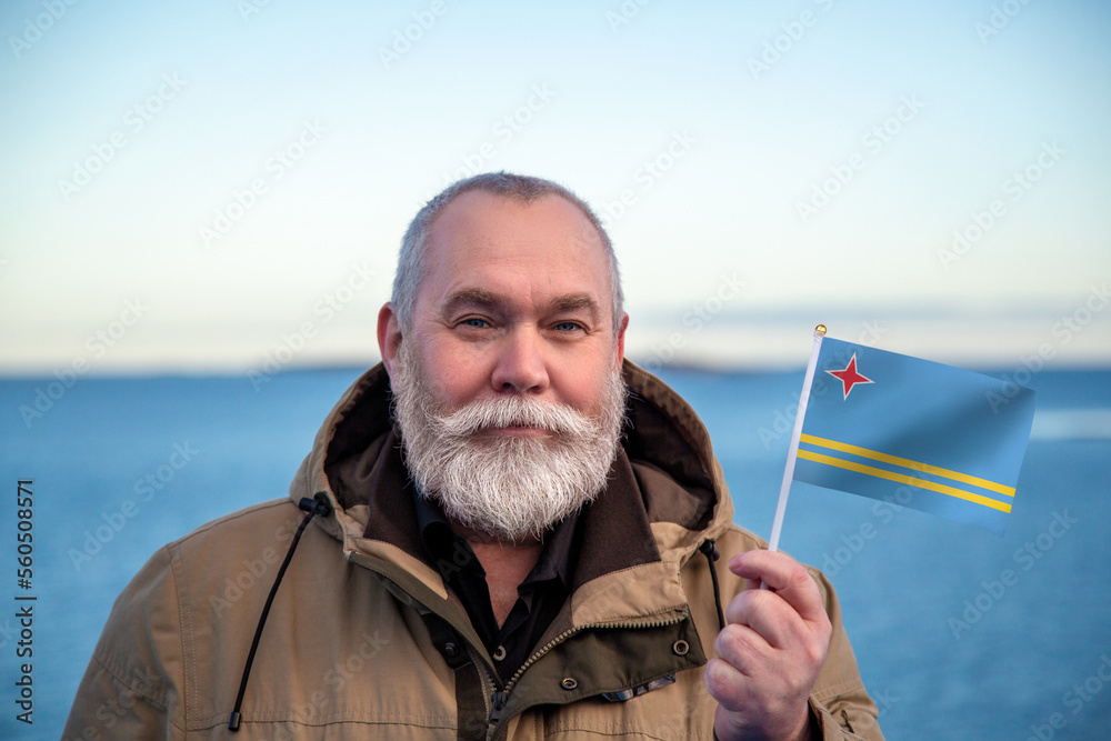 Stockfoto Man holding Aruba flag. Portrait of older man with a national