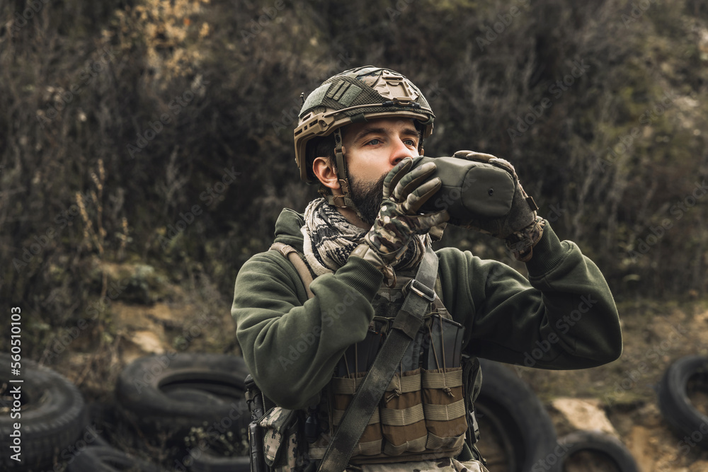 Soldier in military uniform drinking from flask