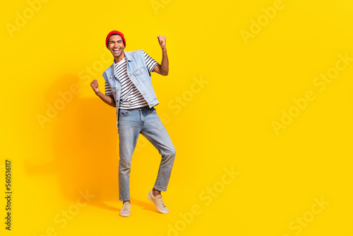 Full size photo of cheerful delighted man raise fists luck empty space ad isolated on yellow color background
