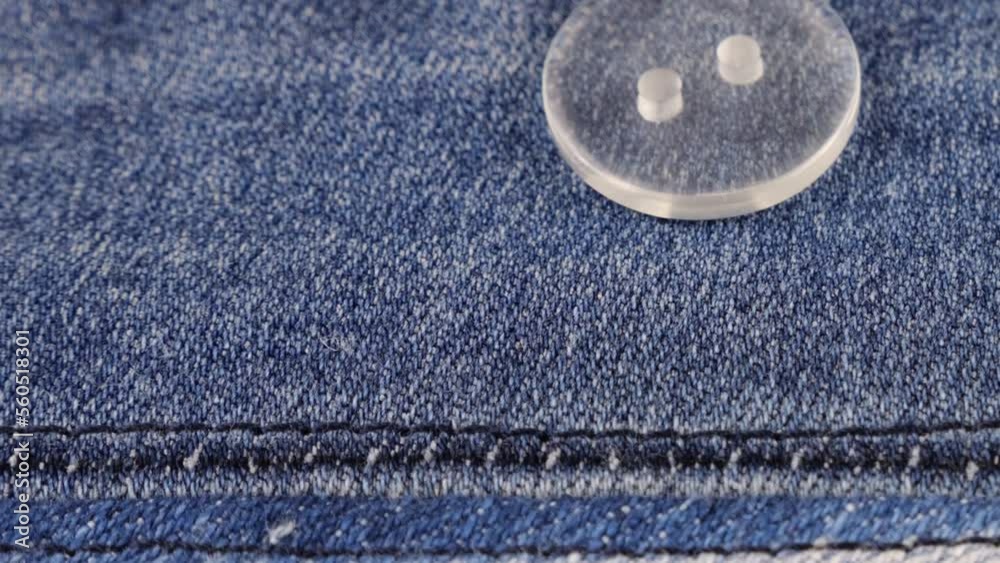 Plastic buttons fall on denim. Plastic buttons fall on denim.