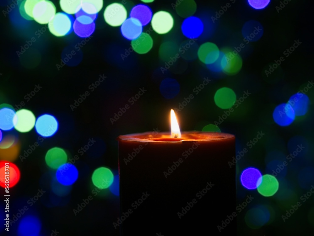 Candle is burning against blurred lights Candle is burning against blurred lights