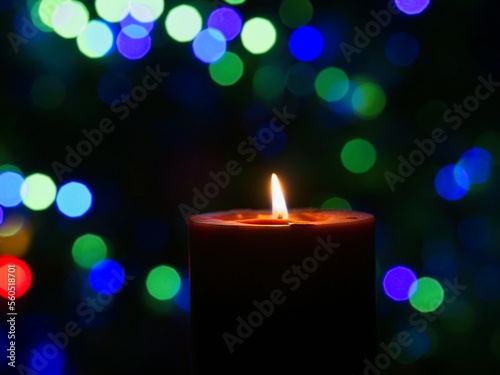 Candle is burning against blurred lights