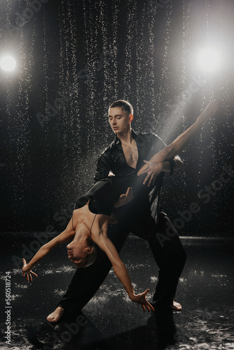 Fototapeta Naklejka Na Ścianę i Meble -  A couple of dancers on a black background in a studio in the aqua zone