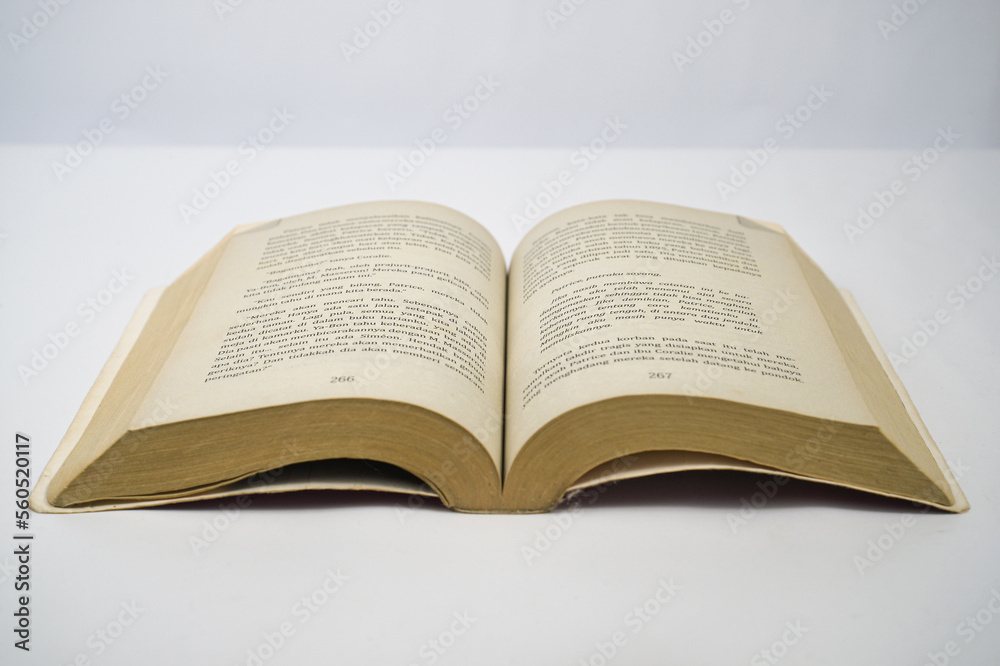 Yogyakarta, Indonesia - January 06, 2023: Open old book on white background. Photographed using focus focus technique. Yogyakarta, Indonesia - January 06, 2023: Open old book on white background. Photographed using focus focus technique.
