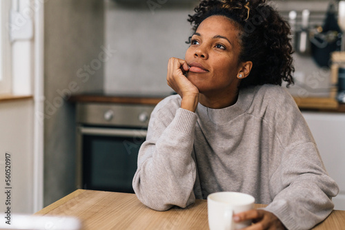 Фотография Pensive woman sits in the kitchen