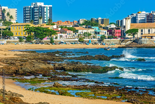 Rio Vermelho beach which is known as the bohemian neighborhood of the city of Salvador in Bahia with its rocks, boats and houses on a sunny summer day photo