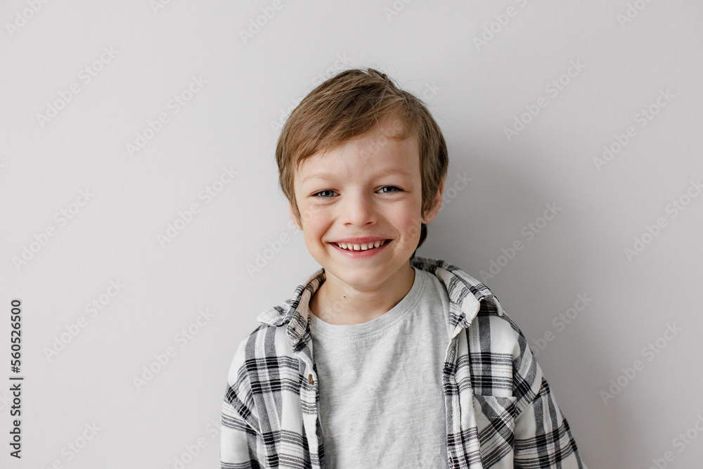 Happy little boy smiling to the camera. Grey studio background. Happy little boy smiling to the camera. Grey studio background.