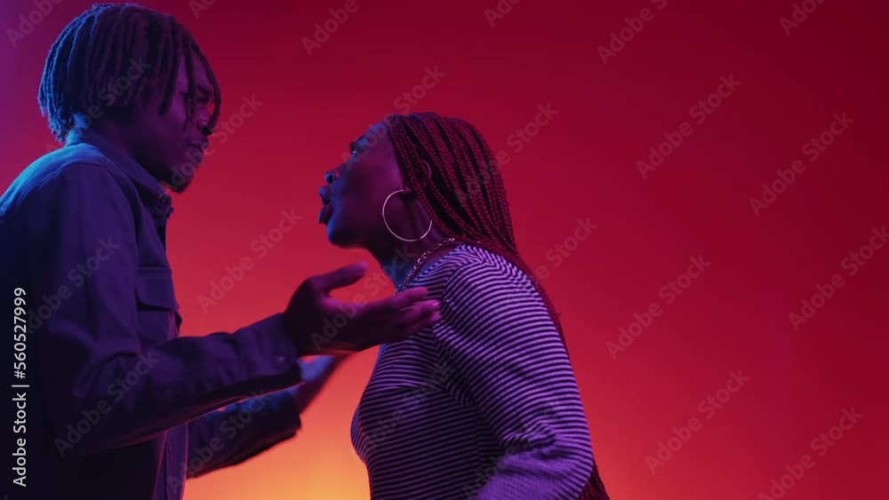 Problem relationship. Couple quarrel. Neon light portrait. Angry black woman and man screaming each other posing blue red background copy space.