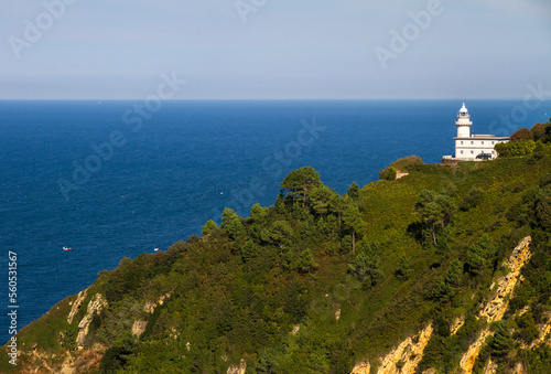 Lighthouse on Mountainside in spain, with blue sea background
