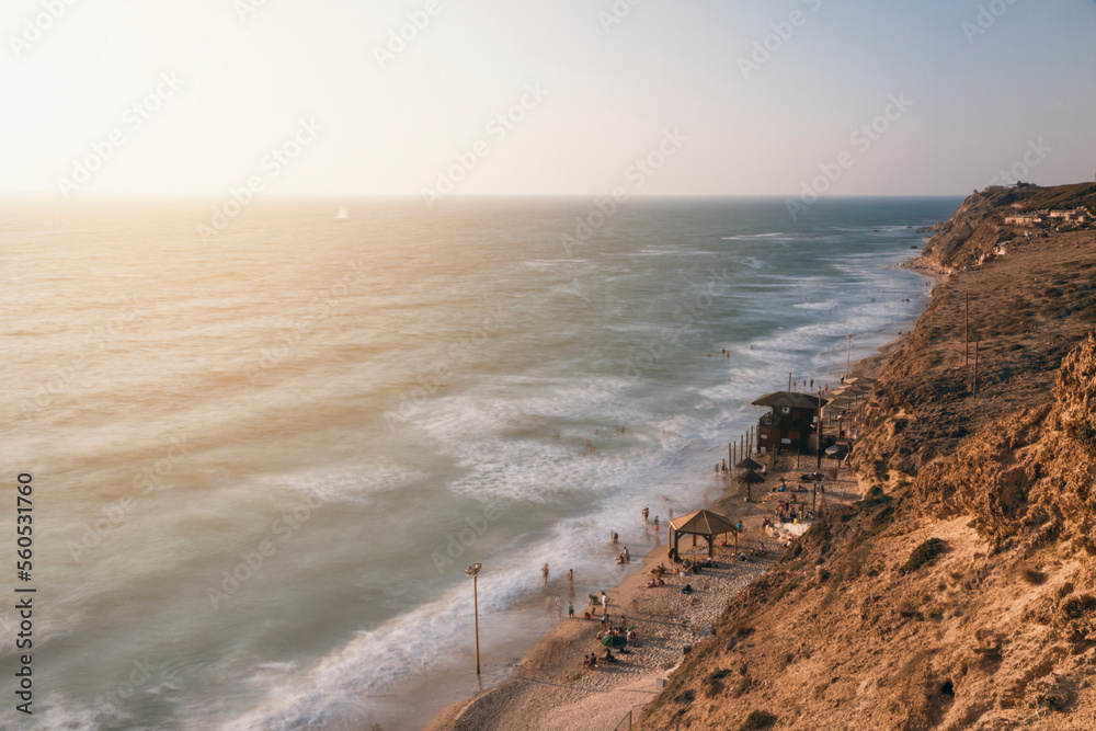 summer view of israeli crowded Beach shoreline from above with sunset at the background summer view of israeli crowded Beach shoreline from above with sunset at the background