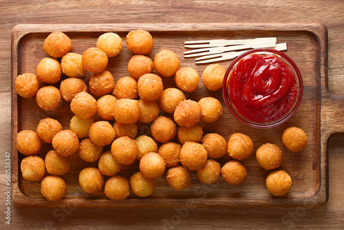 Canvas-taulu Fresh round baked Duchess potatoes or croquettes on wooden plate with ketchup in