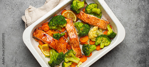 Fotografie Top view of healthy baked fish salmon steaks, broccoli, cauliflower, carrot in casserole dish
