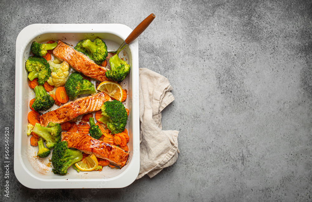 Φωτογραφία Top view of healthy baked fish salmon steaks, broccoli, cauliflower, carrot in casserole dish on gray stone background