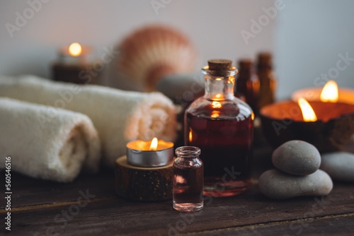 Concept of natural essential organic oils  Bali spa  beauty treatment  relax time. Atmosphere of relaxation  pleasure. Candles  towels  dark wooden background. Alternative oriental medicine