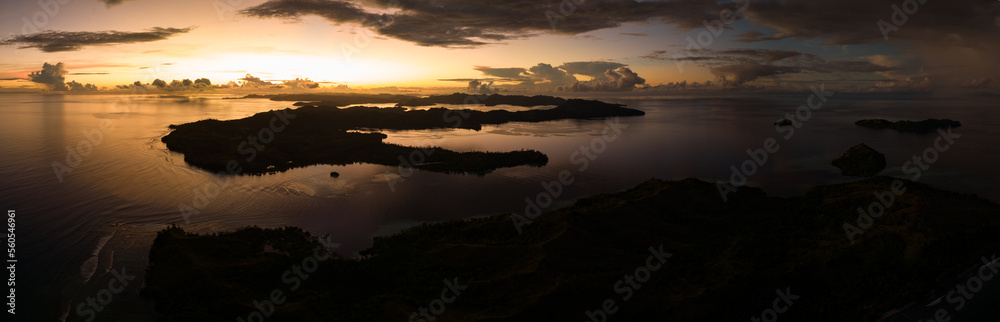 Sunrise illuminates clouds that drift over the calm waters of the Solomon Islands. This scenic region is known for its high marine biodiversity and World War II history.