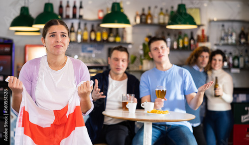 Valokuva Company of upset young adult sports fans holding flag of England and worrying ab