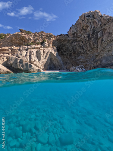 Underwater split photo of famous paradise turquoise pebble beach of Seychelles in island of Ikaria, Aegean sea, Greece