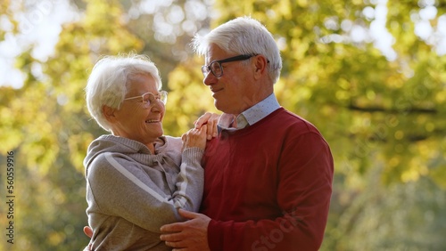 Smiling senior couple standing close together outdoor in nature. High quality photo