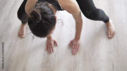 Fit young woman practicing yoga, standing in head to knees, Ardha uttanasana exercise, Half stending forward bend pose in a relaxed home enviroment photo