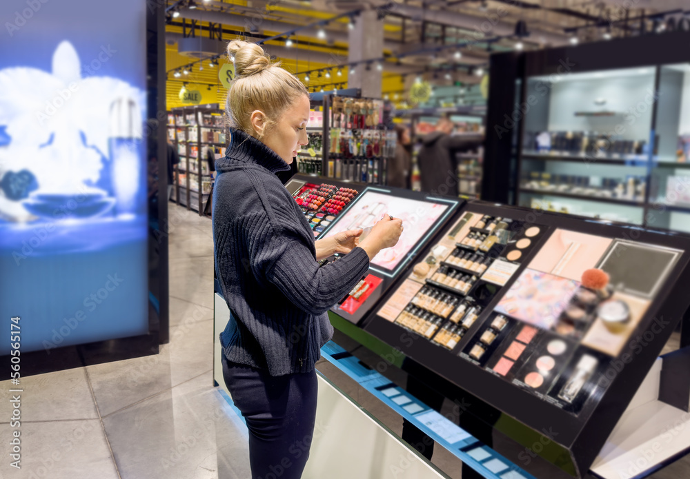 Woman buying make up at cosmetics section in store. choosing cosmetics, perfumes, creams and shampoos, Using tester.