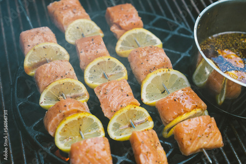 Grilled salmon and lemon skewers on a smokey bbq during a summer day  (ID: 560567311)