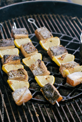 Grilled salmon and lemon skewers on a smokey bbq during a summer day  (ID: 560567328)