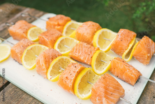 Grilled salmon and lemon skewers on a smokey bbq during a summer day  (ID: 560567333)