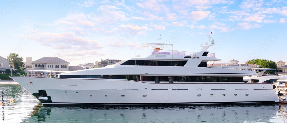 Luxury yachts docked in sea port at sunset, sea tourism and vacation concept Luxury yachts docked in sea port at sunset, sea tourism and vacation concept