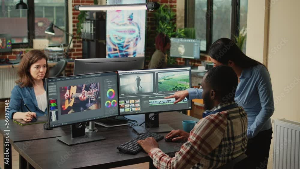 Diverse videographers editing creative film montage on software, brainstorming ideas to improve focus and lighting. Man and woman working with post production video and audio footage.