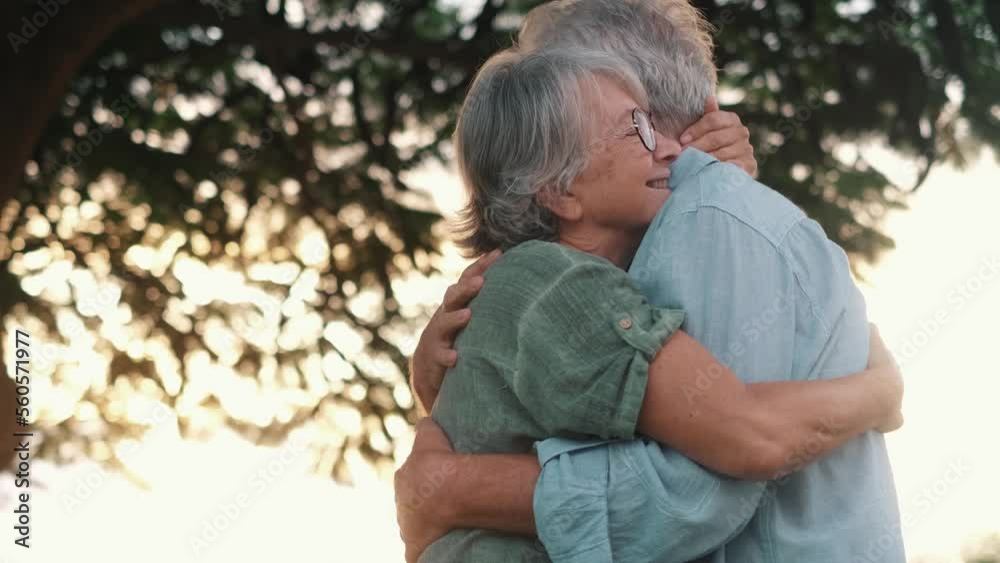 Head shot close up portrait happy grey haired middle aged woman snuggling to smiling older husband, enjoying tender moment at park. Bonding loving old family couple embracing, feeling happiness.