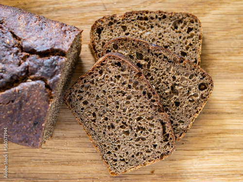 Top view of sliced wholegrain rye bread on wooden background closeup.