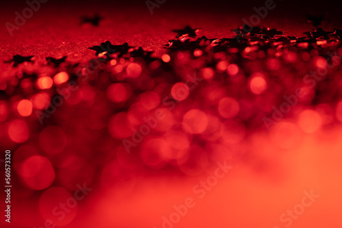 Red glitter and glittering stars on dark background