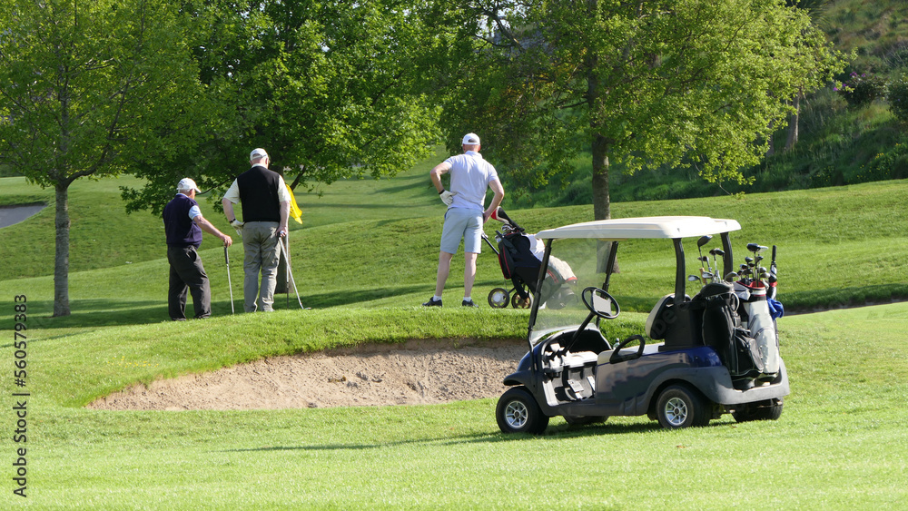 Gentlemen Golfers playing a round of golf on a sunny day at a course on a resort in UK Gentlemen Golfers playing a round of golf on a sunny day at a course on a resort in UK