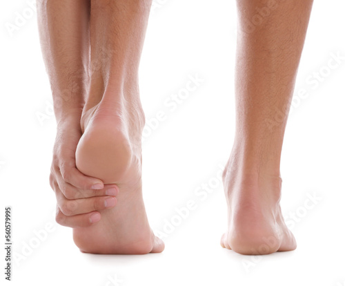 Back view of man suffering from foot pain on white background, closeup